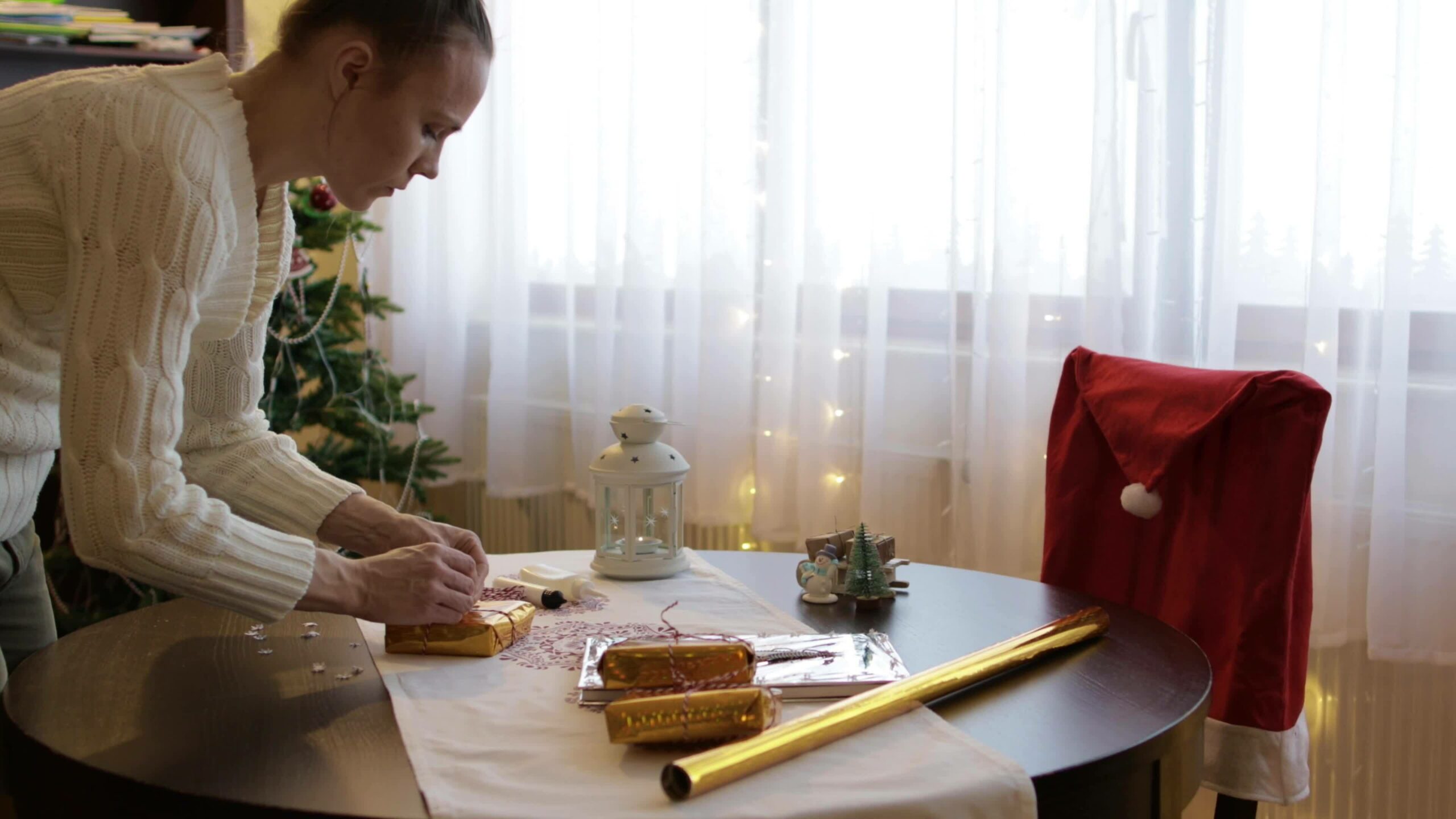 Young lady between 30 and 35 years old prepares Christmas gifts for her